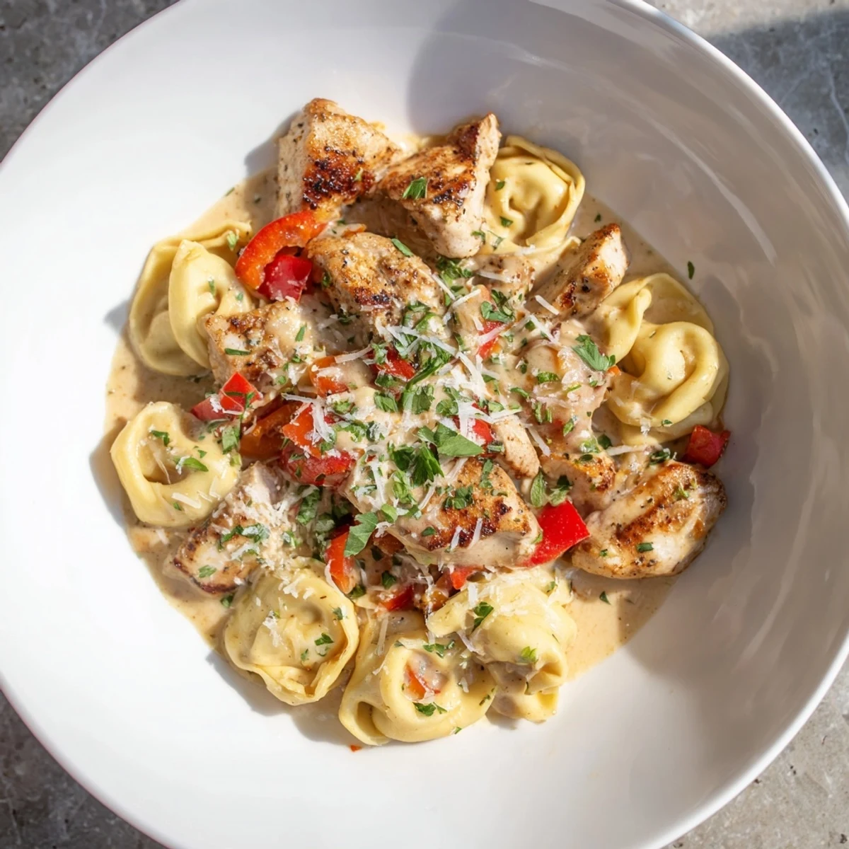 This close-up shows Zesty Cajun Garlic Parmesan Chicken Tortellini, garnished with parsley for a fresh, vibrant flavor.