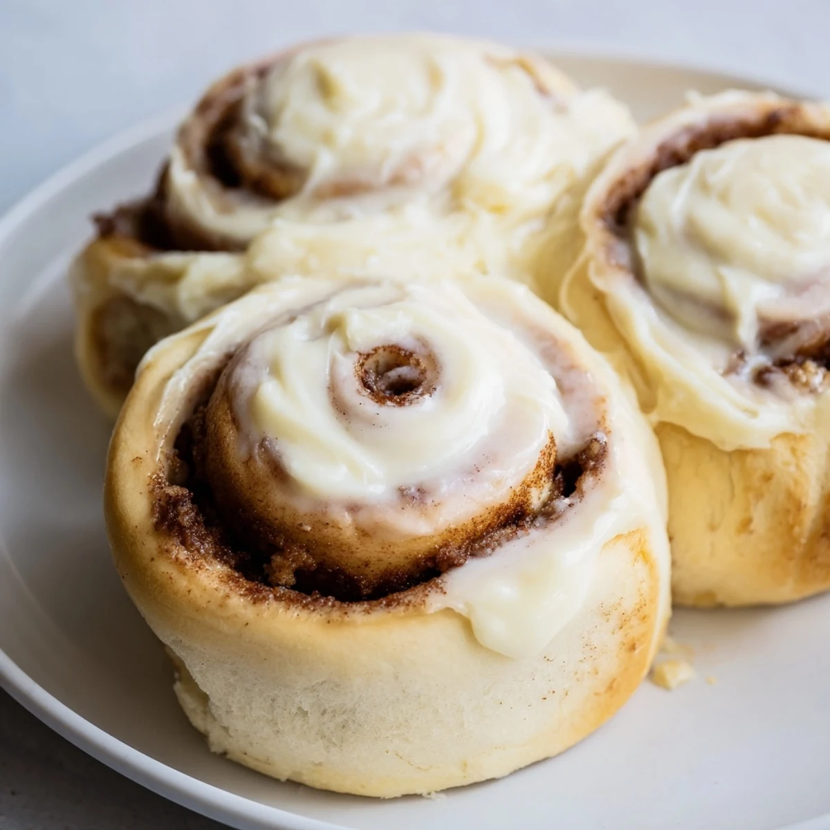 Golden, baked Viral TikTok Heavy Cream Cinnamon Rolls topped with creamy icing, a sweet indulgence.