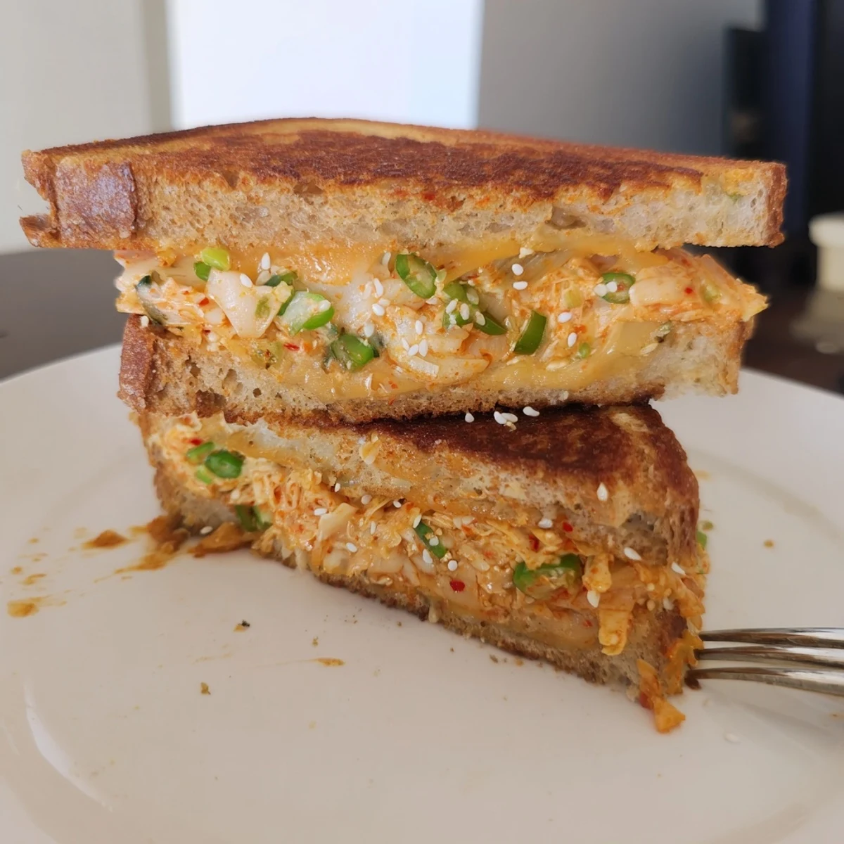 Golden-brown Skillet Kimchi & Cheddar Fusion Grilled Cheese, oozing with melted cheese and spicy kimchi filling.