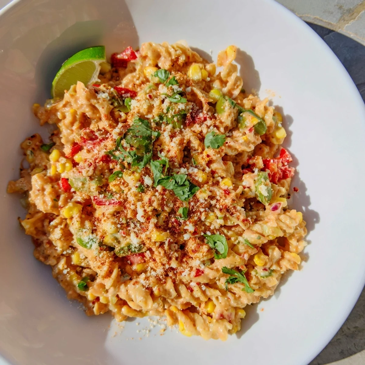 A steaming bowl of One-Pot Mexican Street Corn Pasta, topped with fresh cilantro and cotija.