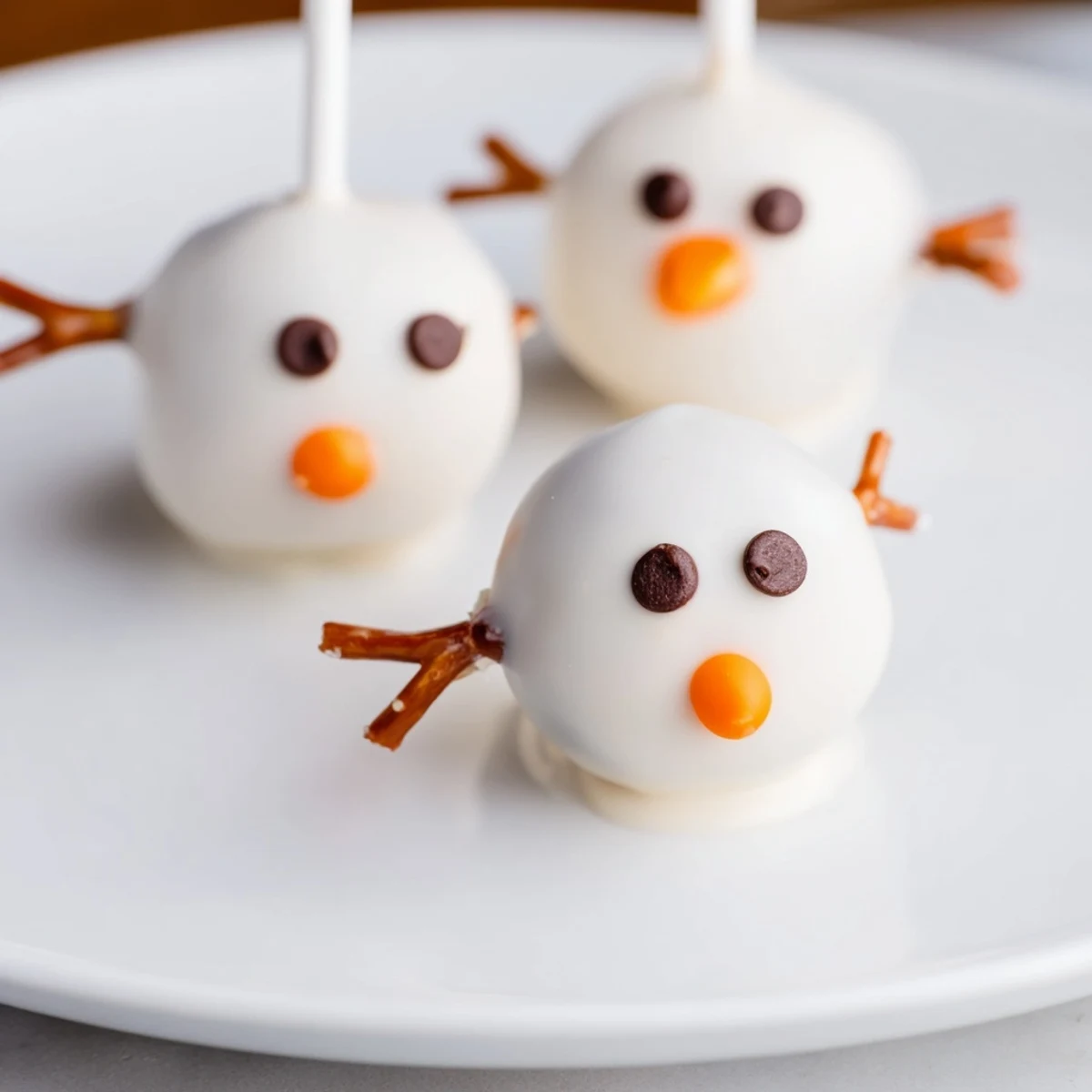Oreo Snowman Cake Pops, coated in white chocolate, ready for a winter holiday treat.