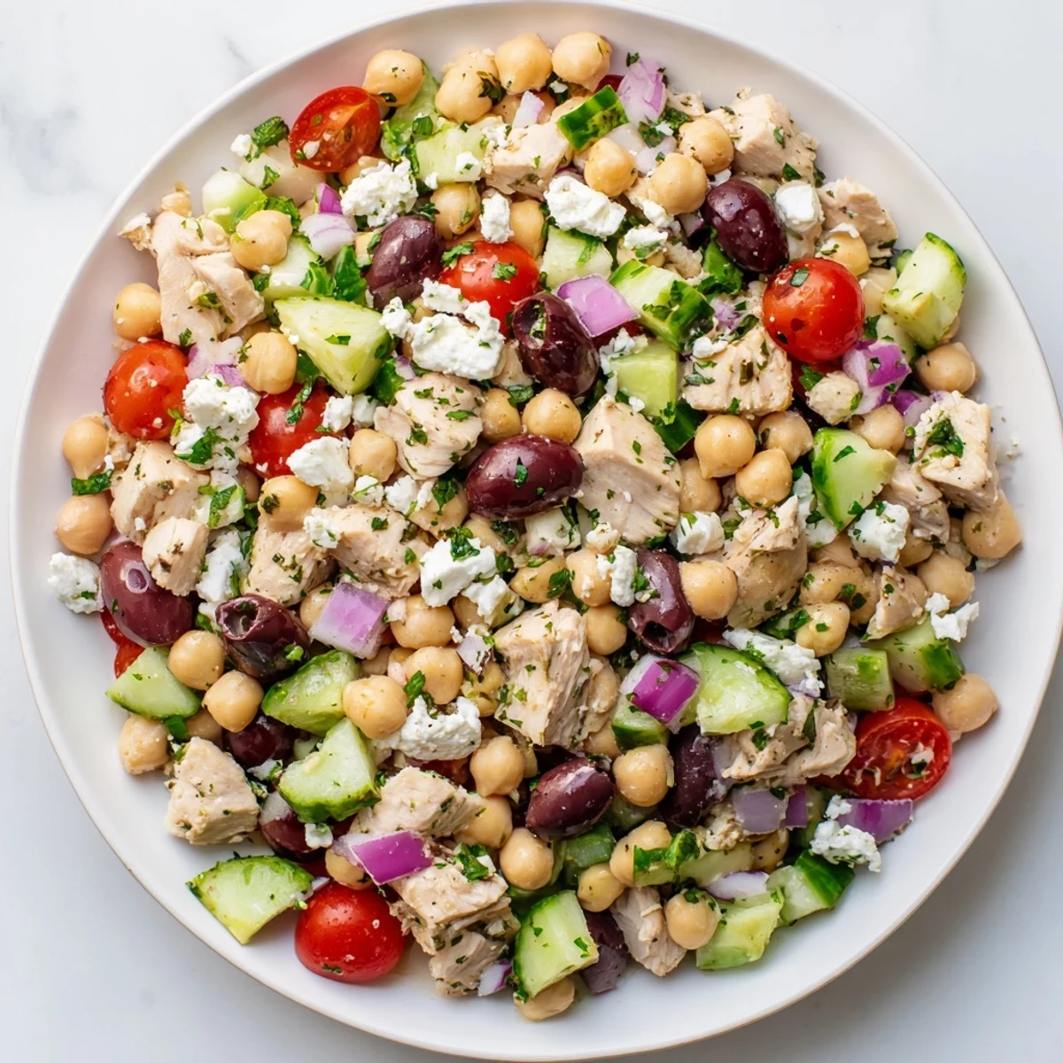 Mediterranean Chickpea Chicken Salad served in a rustic white bowl with fresh parsley.