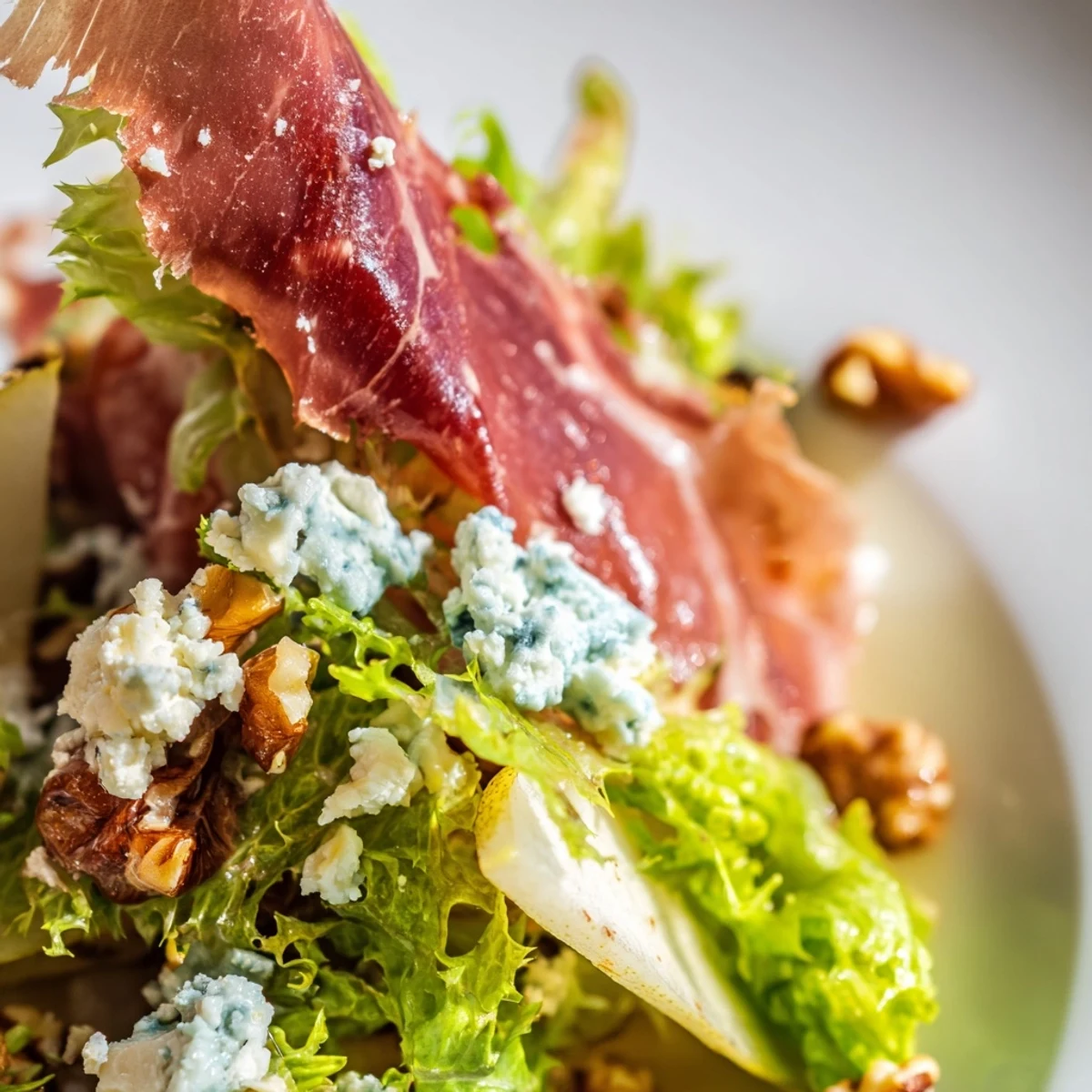 Golden pear slices, crumbled blue cheese, and crisp frisée topped with crunchy prosciutto in this elegant salad.