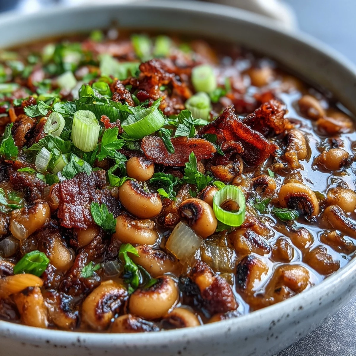 A hearty bowl of Big Pot of Texas Black-Eyed Peas garnished with fresh cilantro and green onions.