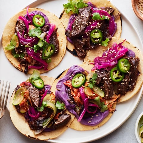 Vibrant Global Street-Food Fusion Tacos topped with ube crema and fresh vegetables.  