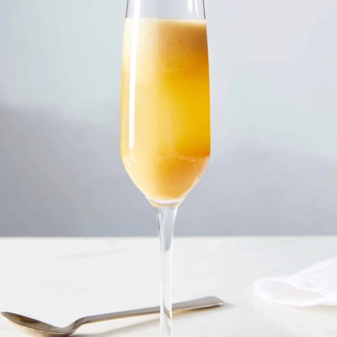 Golden peach bellini drink, summer brunch cocktail, refreshing and fruity Prosecco mix.