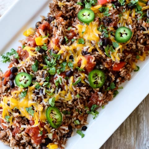 A close-up of a bubbling Tex-Mex Beef & Rice Casserole filled with beef, beans, and melted cheddar.