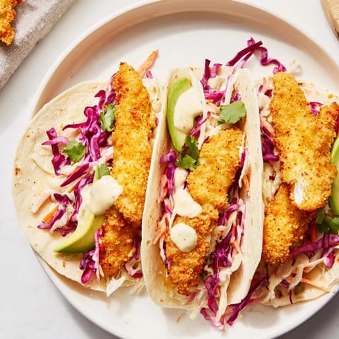 The image shows delicious Crispy Fish Tacos, arranged with avocado and lime for serving.