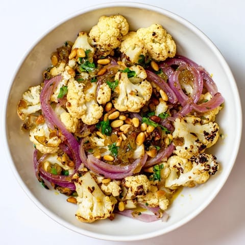 Vibrant Warm Roasted Cauliflower & Lemon Pine-Nut Dressing Salad, ready to serve with toasted pine nuts.