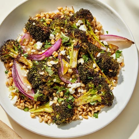 Golden-brown roasted broccoli and red onion beautifully presented in Warm Roasted Broccoli with Garlic-Lemon & Farro.