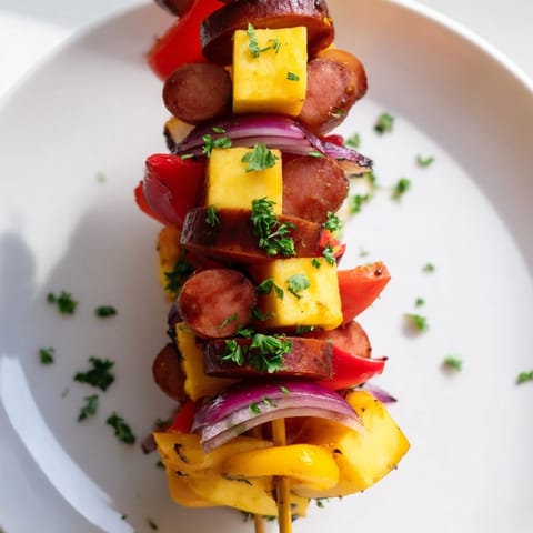 Skewers of savory Chimney Stack Sausage and Cheese showcase melted cheese with charred sausage and peppers, ready to eat.