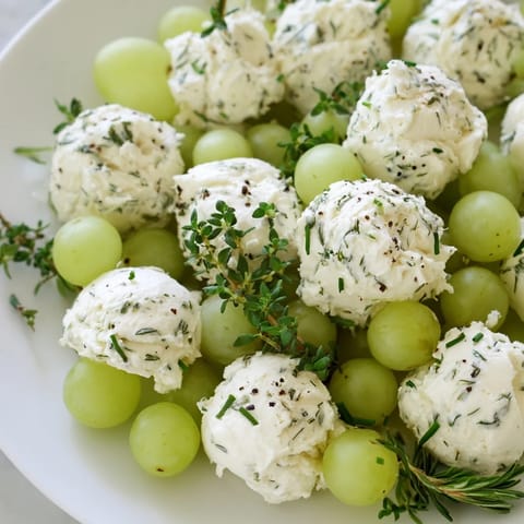 This beautiful Mistletoe Kissing Ball appetizer features green grapes, herbs, and creamy cheese for holidays.