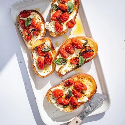 Warm Baked Feta Toast with bubbly feta and juicy tomatoes, served as a savory snack.