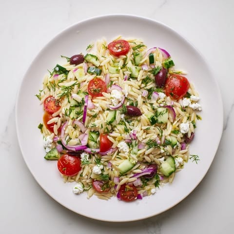 Tender orzo pasta, crisp cucumbers, and juicy tomatoes in a refreshing Greek Orzo Salad topped with crumbled feta cheese.