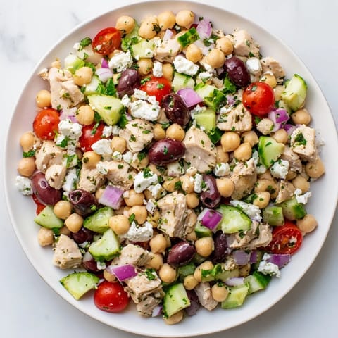 Mediterranean Chickpea Chicken Salad served in a rustic white bowl with fresh parsley.
