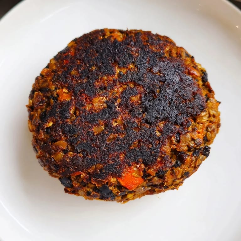 A close-up of a stack of delicious black bean burgers ready to be served on toasted buns.