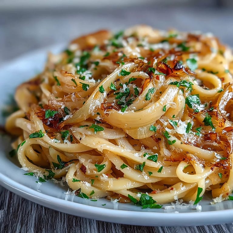 Hearty Cabbage Pasta With Garlic and Parmesan served warm in a white bowl, garnished with lemon zest.